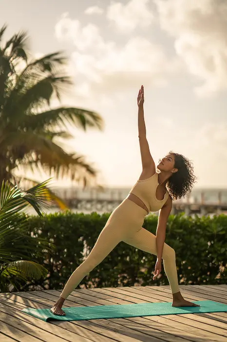 Guest practicing sunrise yoga on open-air deck at Reef Haven Belize wellness resort